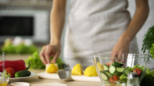 Cooking amateur making fresh salad at home kitchen  dressing with lemon juice