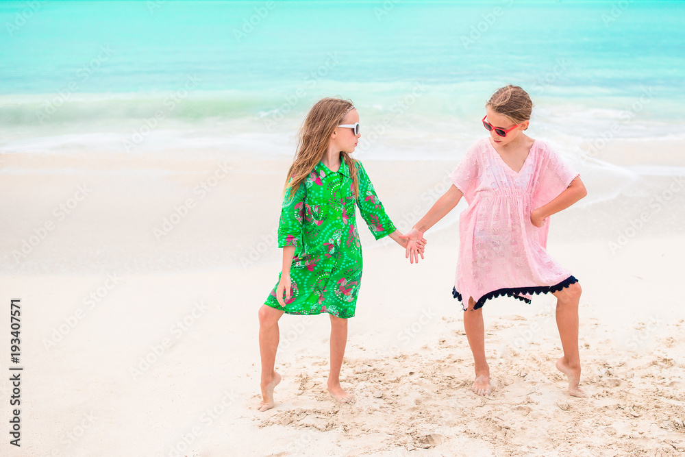 Little girls having fun at tropical beach playing together
