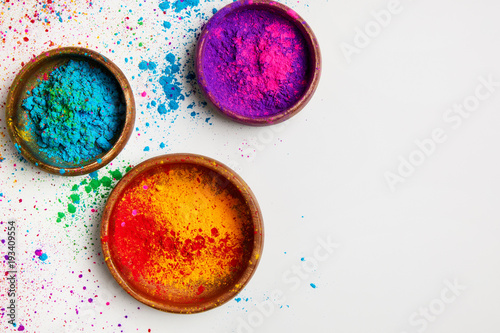 top view of colorful traditional holi powder in bowls isolated on white