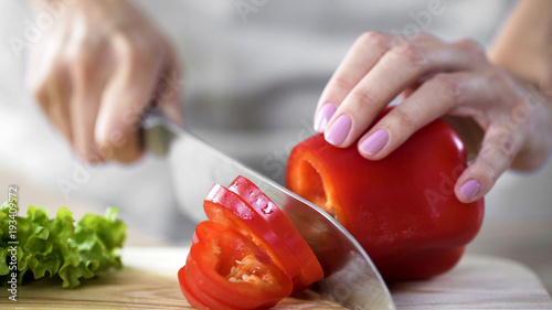 Mother cutting pepper for lunch salad in kitchen at home, healthcare, hobby