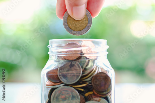 Hand saving a coin into the...