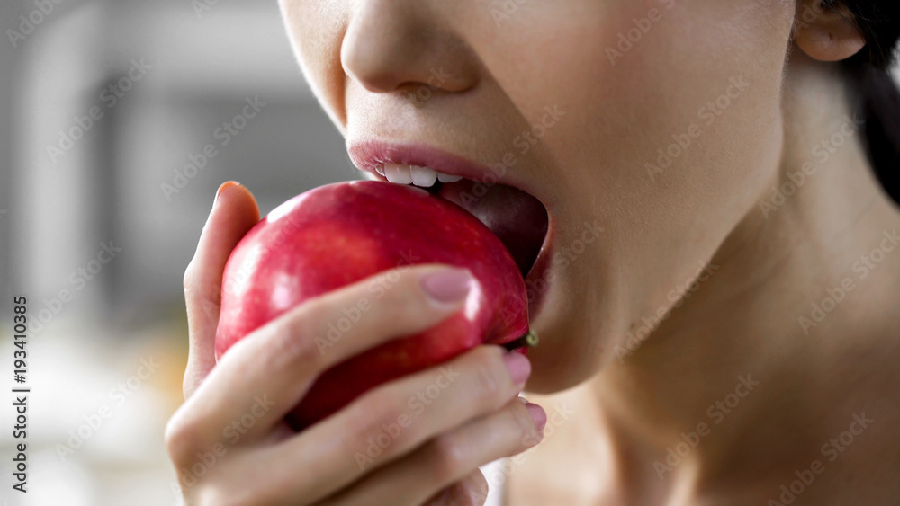 Hungry girl with great appetite biting big juicy apple, healthy snack at work Hungry girl with great appetite biting big juicy apple, healthy snack at work