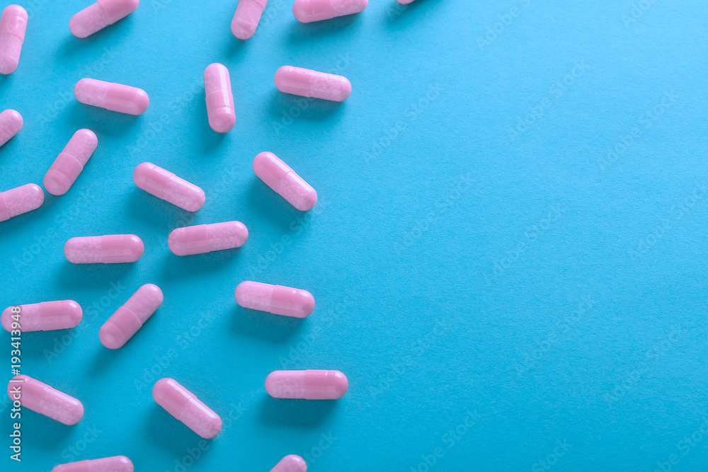 pink pills on blue background top view pink pills on blue background top view