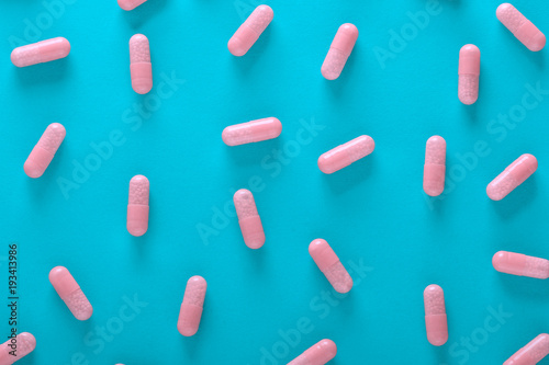 pink pills on blue background top view