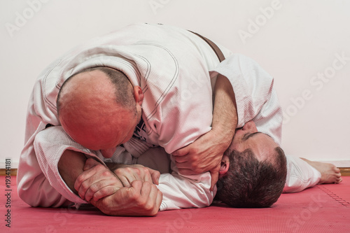 Brazilian jiu-jitsu training demonstration in traditional kimono photo