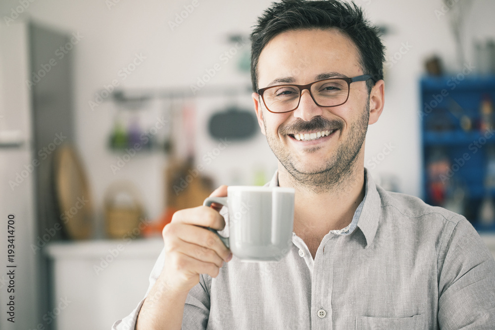 Happy smiling man looking camera and having cup of coffee Happy smiling man looking camera and having cup of coffee