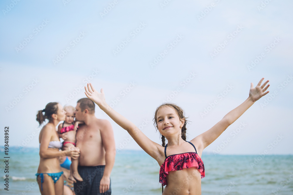 Family dad, mom, girl and baby on the beach on sea background beautiful and happy Family dad, mom, girl and baby on the beach on sea background beautiful and happy