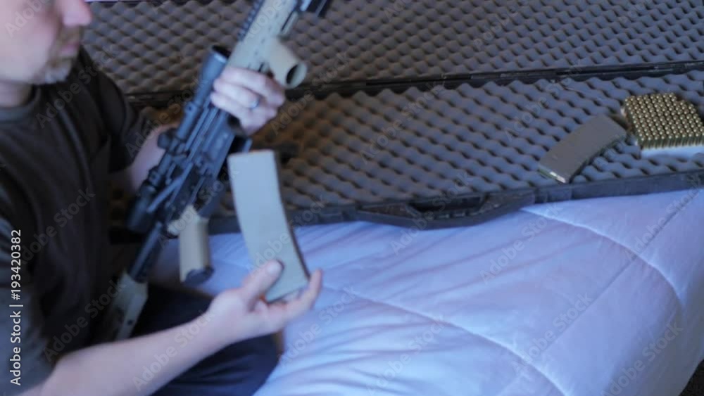Man removes assualt rifle from a case.