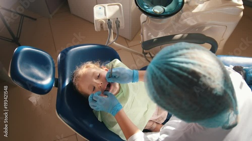 Girl on reception at the dentist, the stomatologist carrying out the cleaning procedure photo