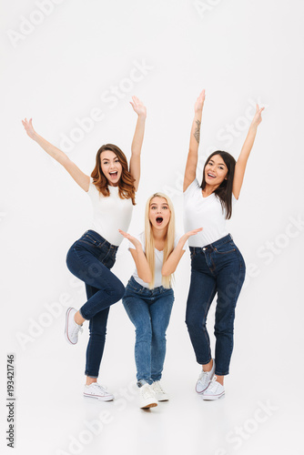 Full length portrait of three happy casual girls