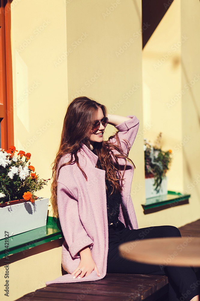 portrait of a stylish smiling woman in sunglasses in urban style portrait of a stylish smiling woman in sunglasses in urban style