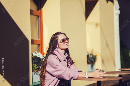 Fashion portrait pretty woman in casual style sitting in cafe