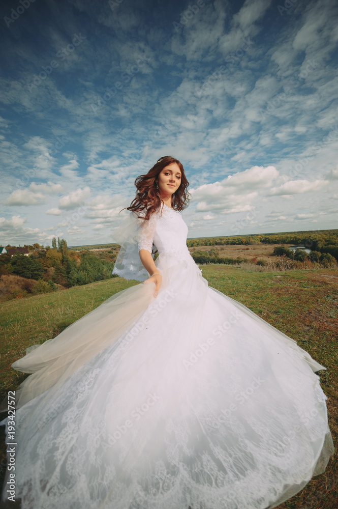 the bride is spinning in the field. flying dress