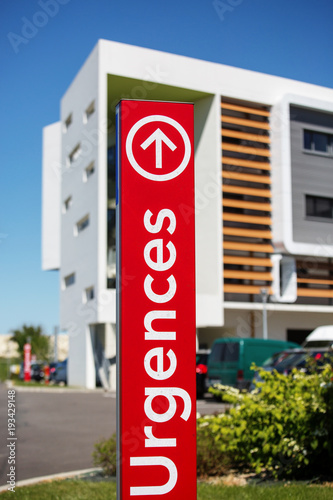 Closeup of vertical red sign - "Emergency" ("Urgences" in French).