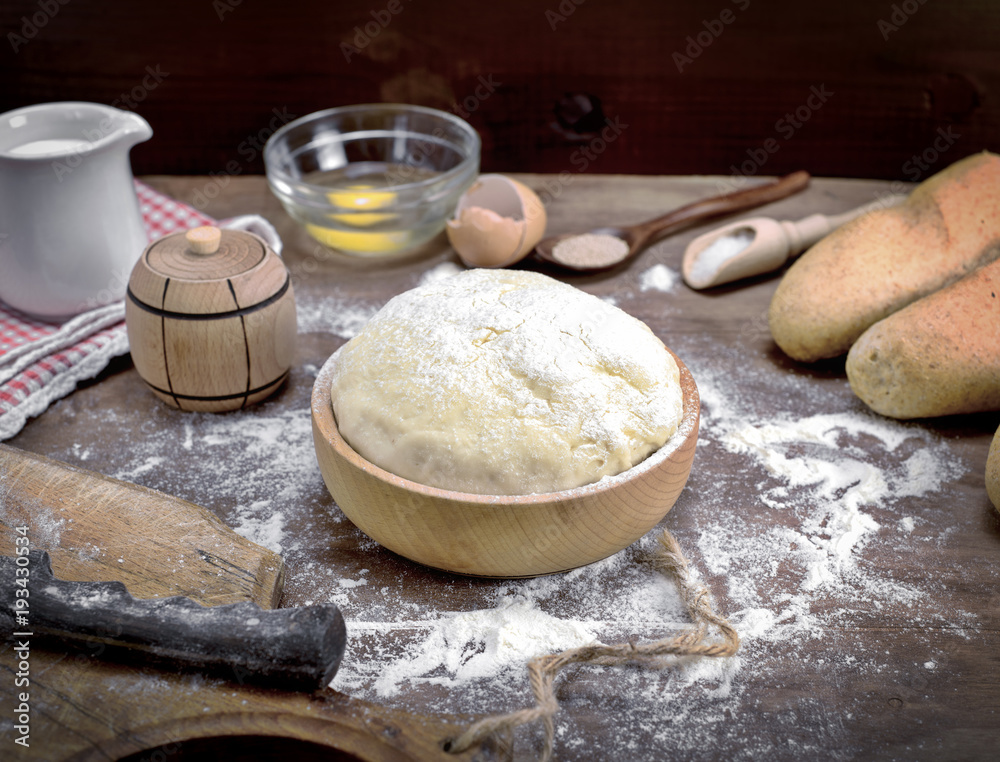 wheat yeast dough in a wooden bowl on a table wheat yeast dough in a wooden bowl on a table