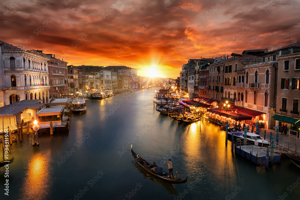 Romantischer Sonnenuntergang über dem Canal Grande in Venedig mit vorbeifahrender Gondel