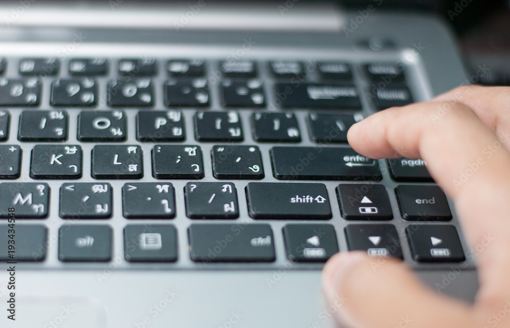 An index finger is about to press on enter button of a computer laptop keyboard An index finger is about to press on enter button of a computer laptop keyboard