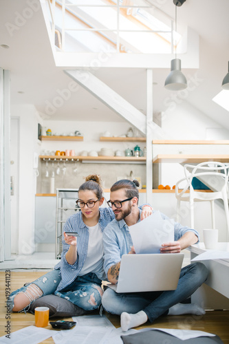 Young couple paying bills with credit card 