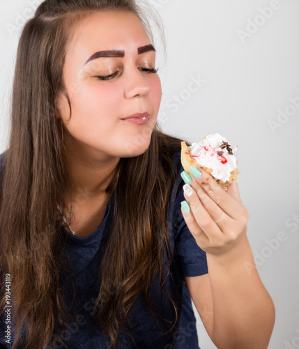 Young woman eating cupcakes with pleasure after a diet