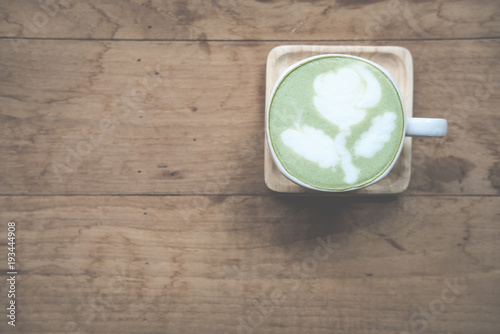 hot matcha green tea latte drink with milk topping in white mug. top view