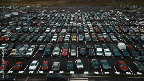 Aerial view of large amount of automobiles parked near mall photo