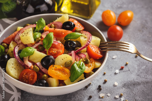 Potato salad with tomatoes, olives, capers, red onion, italian style cuisine. Insalata Pantesca.