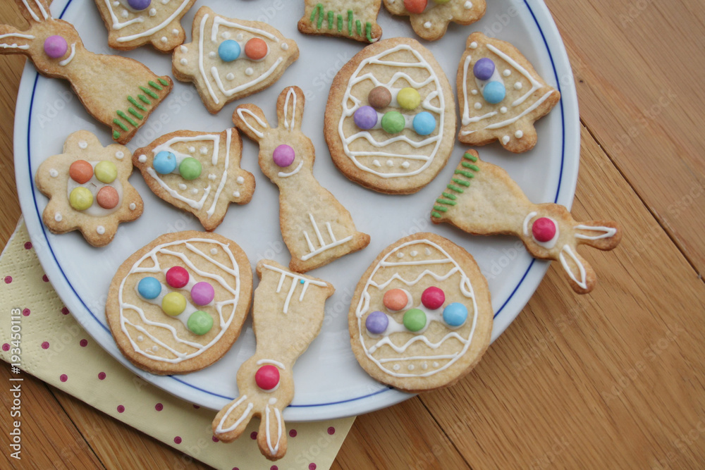 Easter glazed cookies in shape of egg, bunny, flower and bell on wooden background Easter glazed cookies in shape of egg, bunny, flower and bell on wooden background