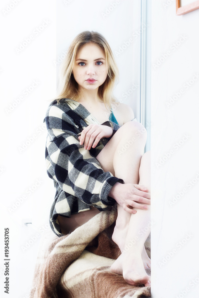 girl in a shirt by the window sill girl in a shirt by the window sill