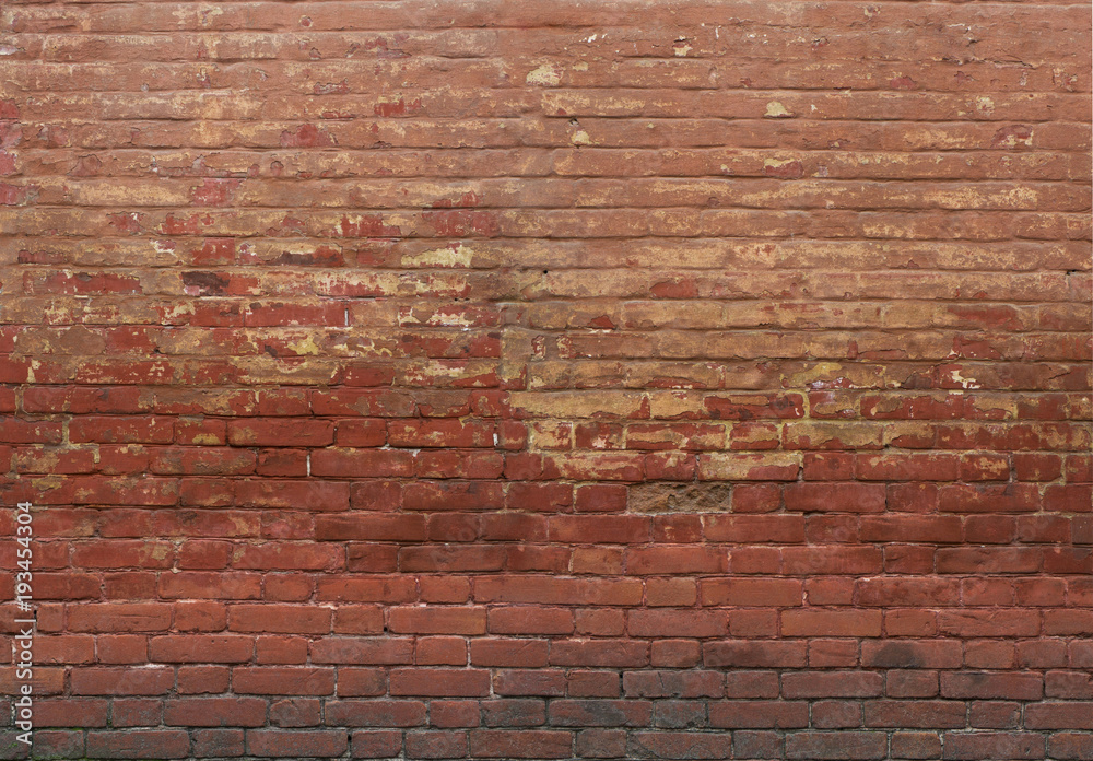 Red brown brick stone wall. Old grungy rough texture on facade of building. Horizontal wide brickwork fence.