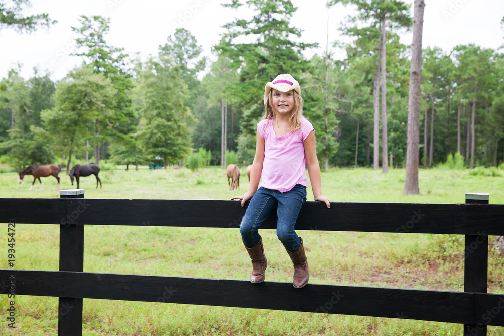 Little Girl on a Fence at a Horse Farm and Ranch