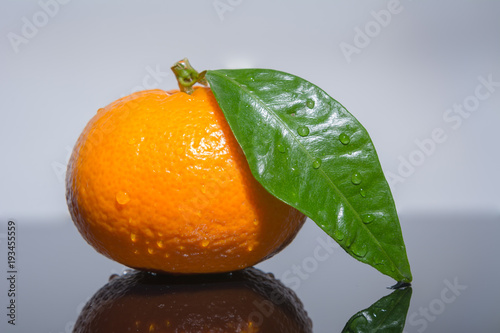 Bio Obst - Madarine , Orange mit grünem Blatt photo