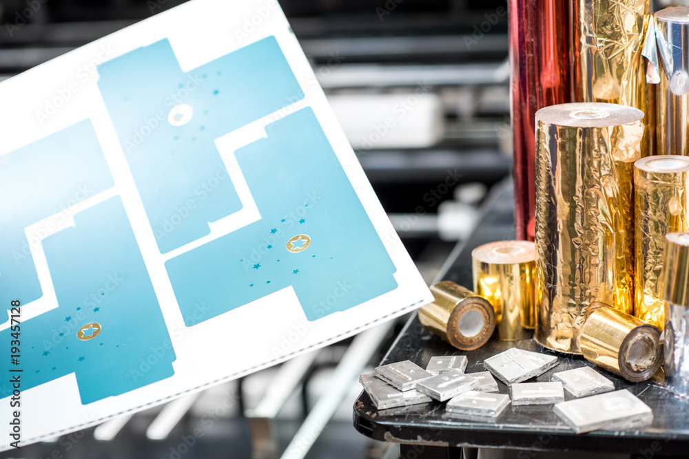 Obraz premium Print sample with foil rolls and cliche for stamping on the press machine at the printing manufacturing
