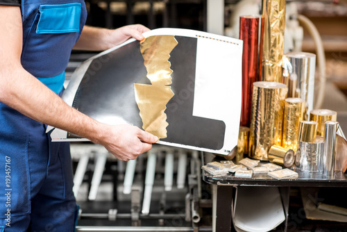Obraz na płótnie Worker checking the quality of the foil stamping at the manufacturing