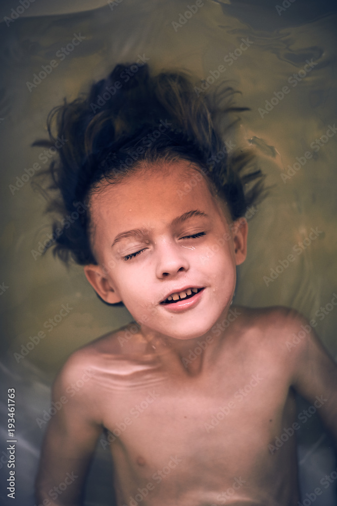 Cheerful boy lying in bath Cheerful boy lying in bath