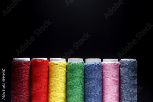 Sewing Quilting Thread, Rainbow colors. on black background with place for your own text photo