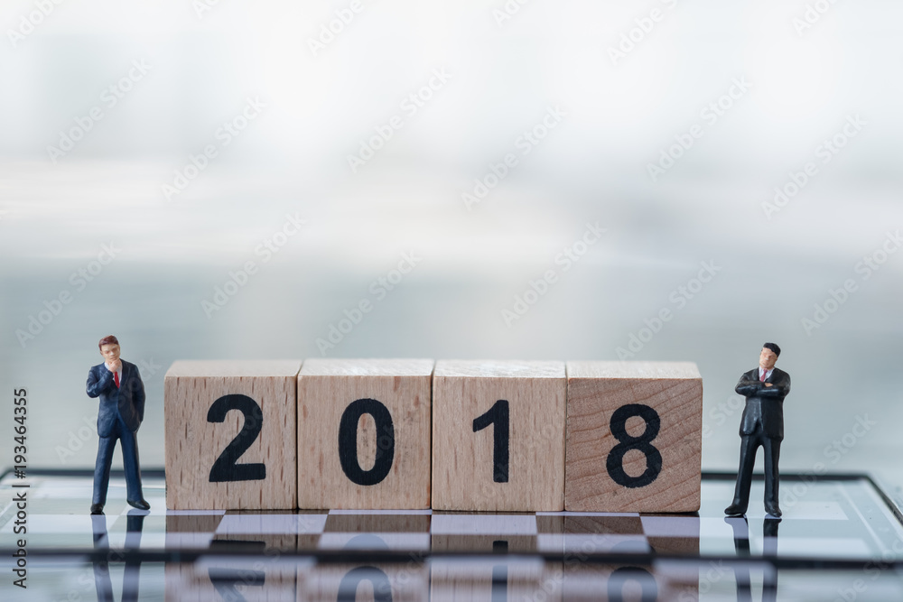 2018 New Year planning and Business concept. Two Businessman miniature figures standing on chessboard with wooden number blocks 2018 New Year planning and Business concept. Two Businessman miniature figures standing on chessboard with wooden number blocks