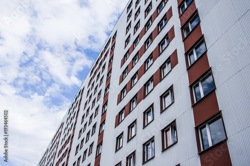 Block of flats high in the blue cloud sky.