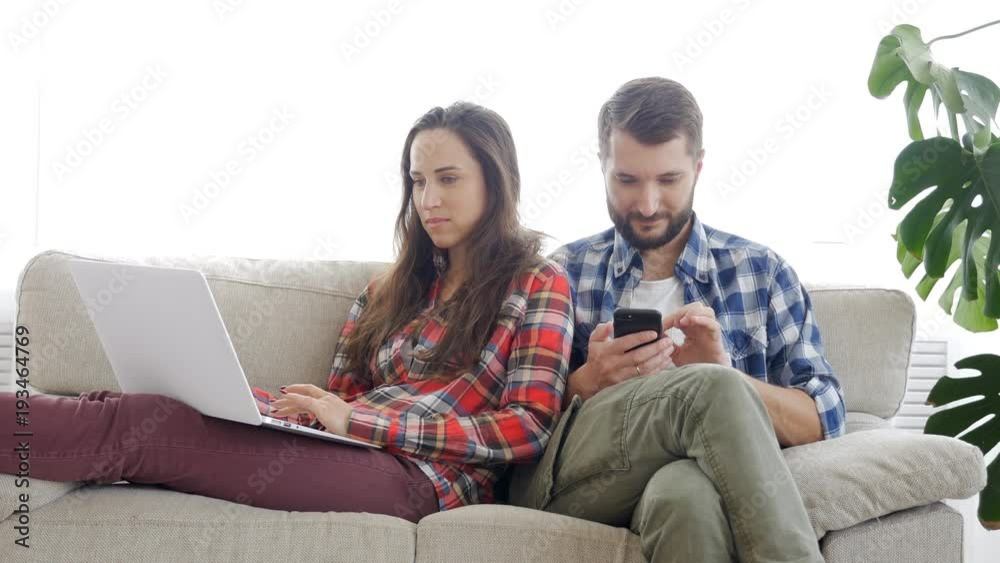 Young couple resting on the couch next to the window Young couple resting on the couch next to the window