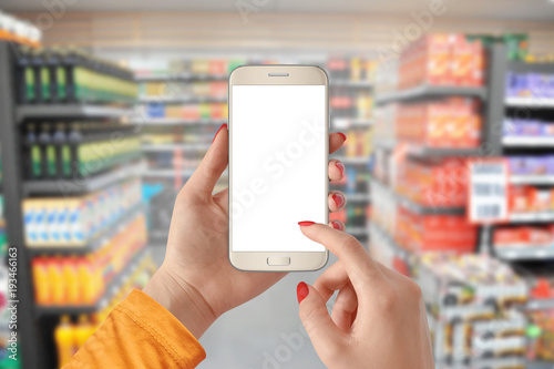 Woman using smartphone with isolated screen and shopping at the supermarket