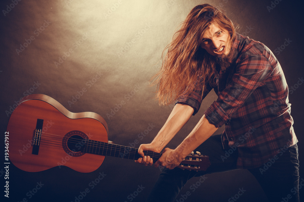 Obraz premium Rock musician destroys his guitar.