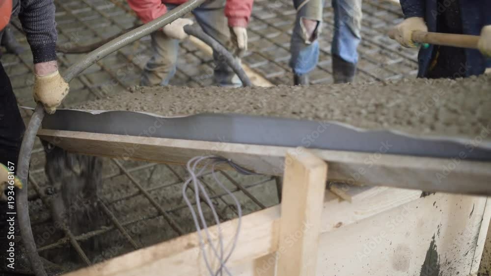 workers are laying of concrete mix in over reinforcing cage for making a floor of building, from concrete pump workers are laying of concrete mix in over reinforcing cage for making a floor of building, from concrete pump