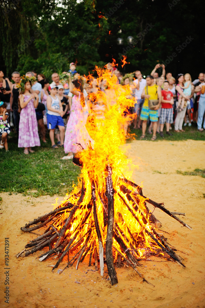 Naklejka premium Large Bonfire on the background of people. The celebration of Ivan Kupala