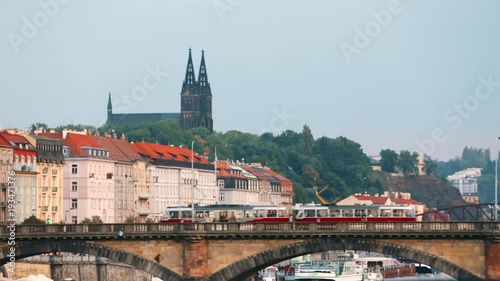 Prague, Czech Republic. Tram Moving In Legion Bridge In Autumn Day. Legion Bridge Or Most Legii And Basilica Of St. Peter And St. Paul On Background photo