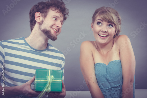 Young man giving woman gift box