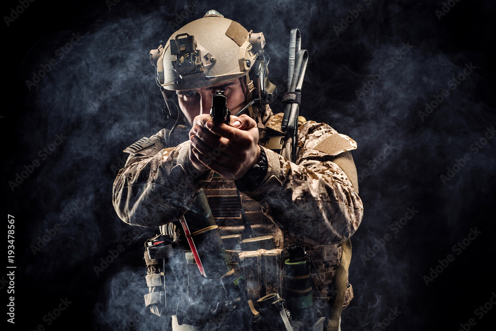 soldier or private military contractor holding rifle. Image on a black ...