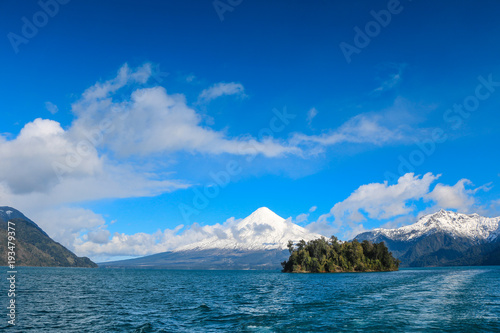 Cruising a Lake Under a Blue Sky with Volcano as Background