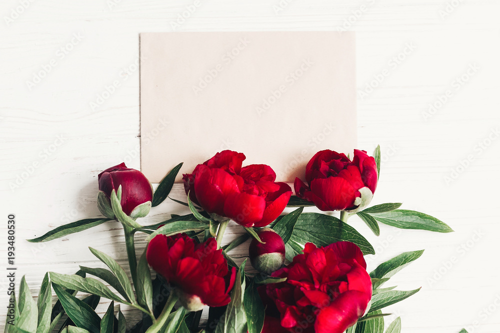 Obraz floral greeting card concept, hello spring stylish image flat lay. beautiful red peonies bouquet on white wooden rustic background, top view. space for text. happy womens mothers day