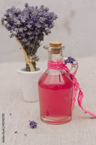 tasty traditional lavender syrup in a bottle glas and lavender flowers
