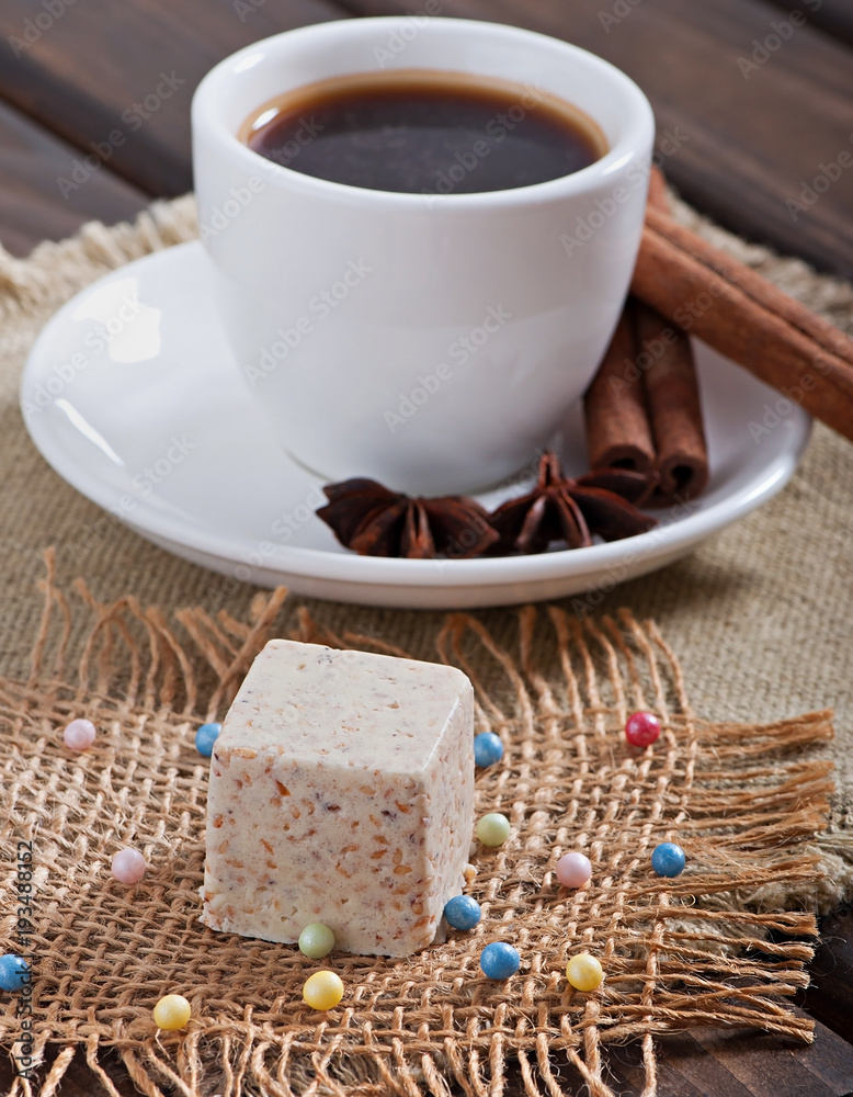 Milk sesame sweets and aromatic coffee with spices on an old wooden background. Milk sesame sweets and aromatic coffee with spices on an old wooden background.