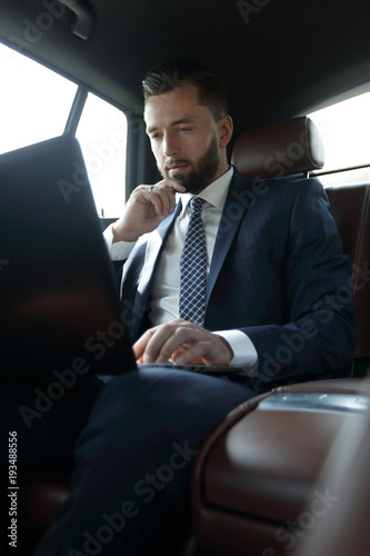 businessman working with laptop and looking out the window of a car © ASDF